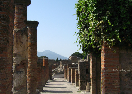 A street in Pompeii, Italy, with Mount Vesuvius in the background. The eruption of Mount Vesuvius in 79 A.D. killed everyone and everything in its path.